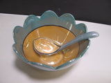 Green and amber bowl with spoon and underplate